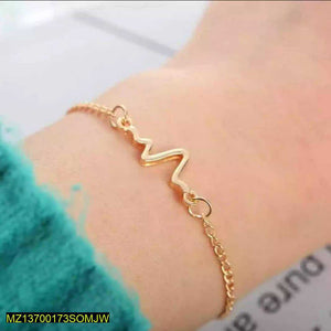 Gold bracelet on a wrist with a blurred background