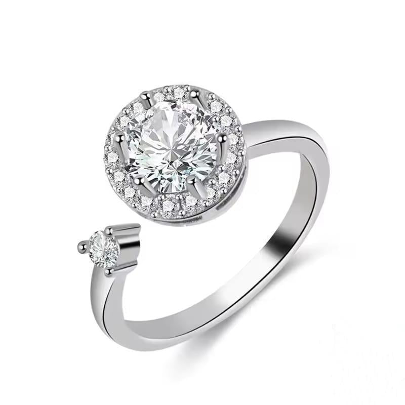 Silver ring with a large diamond and smaller diamonds on a white background